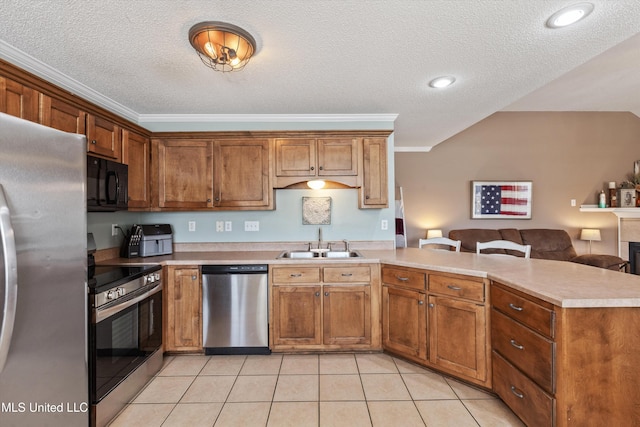 kitchen with light tile patterned floors, stainless steel appliances, light countertops, a sink, and a peninsula