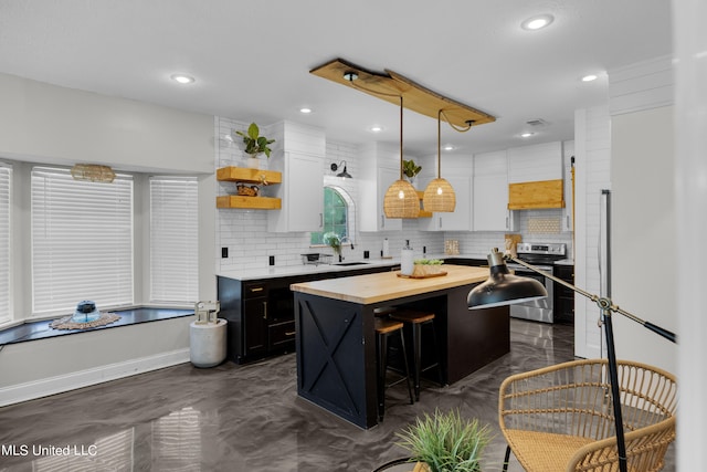 kitchen with electric range, a center island, decorative light fixtures, and white cabinets