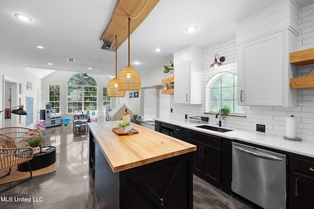 kitchen with white cabinets, stainless steel dishwasher, a wealth of natural light, and a kitchen island