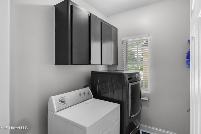 washroom featuring washer and dryer and cabinets