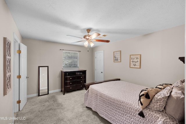 carpeted bedroom with ceiling fan and a textured ceiling