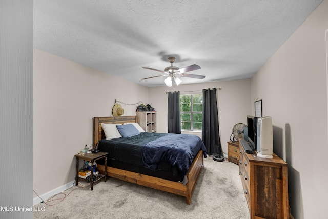 bedroom featuring ceiling fan, a textured ceiling, and light colored carpet