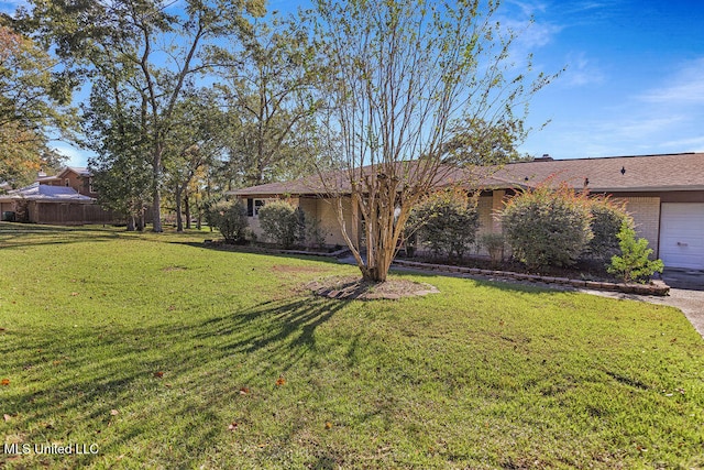 view of front of home featuring a front yard and a garage