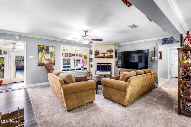 living room with a fireplace, crown molding, hardwood / wood-style floors, and ceiling fan