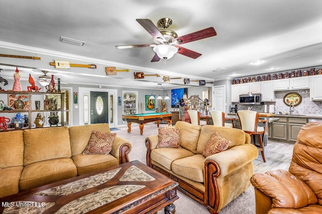 living room with ceiling fan, sink, ornamental molding, and pool table