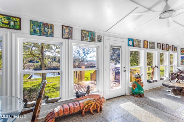 sunroom featuring ceiling fan, french doors, and a water view