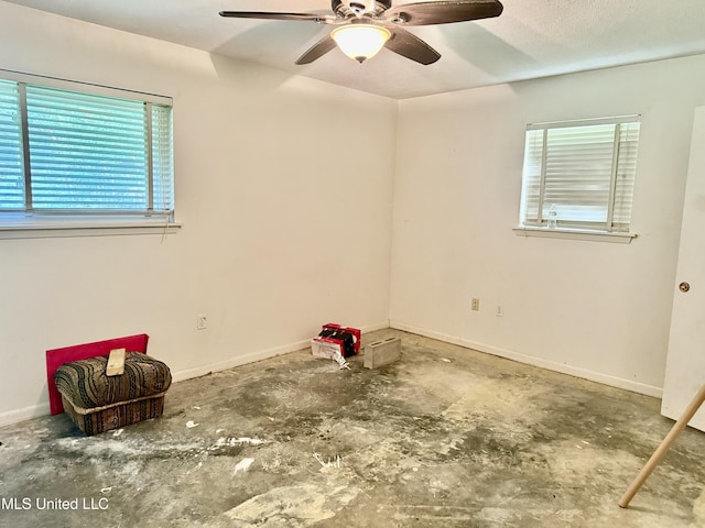 15449 Mimosa Dr, Gulfport, MS 39503 - spare room featuring ceiling fan, healthy amount of natural light, concrete flooring, and baseboards