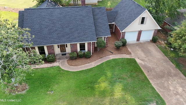 view of front of home with a porch, a front lawn, and a garage