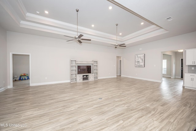 unfurnished living room with a raised ceiling, a ceiling fan, ornamental molding, and recessed lighting