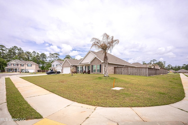 view of front of house featuring fence, a residential view, a front yard, and concrete driveway