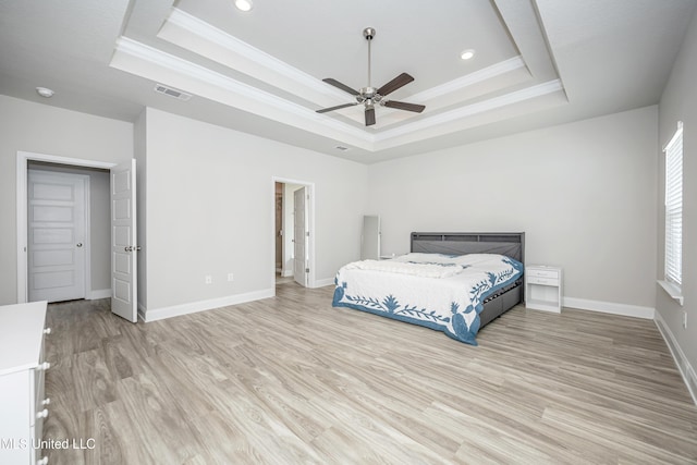bedroom with a raised ceiling, visible vents, and ornamental molding