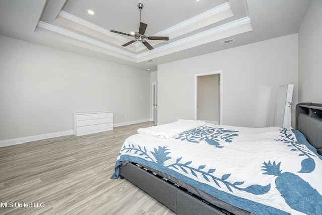 bedroom featuring a raised ceiling, visible vents, ornamental molding, and light wood-style flooring