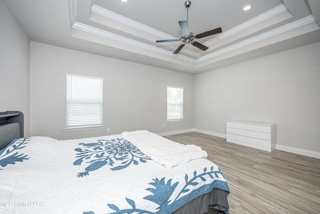 bedroom with wood finished floors, crown molding, a tray ceiling, and recessed lighting
