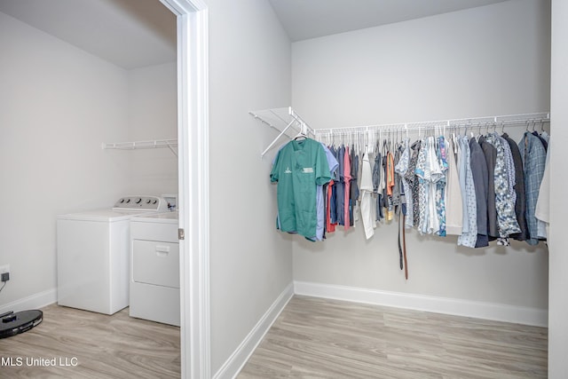 walk in closet with wood finished floors and washing machine and clothes dryer