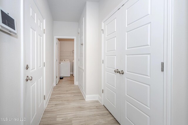 corridor with light wood-style floors, washer / clothes dryer, and baseboards