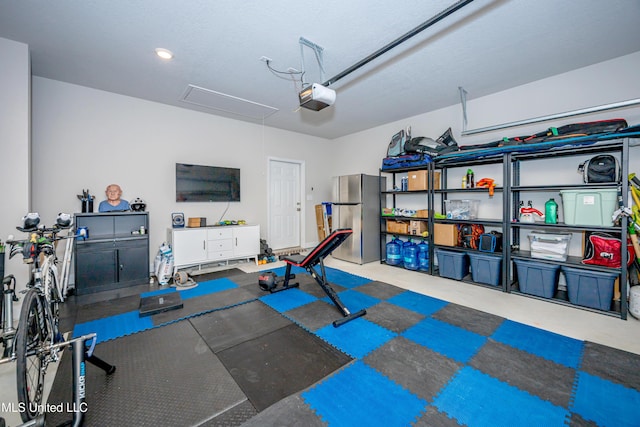 garage with a garage door opener and freestanding refrigerator