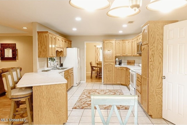 2208 Highland Dr, Gautier, MS 39553 - kitchen featuring light brown cabinets, white appliances, a peninsula, light countertops, and recessed lighting