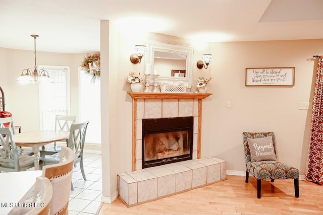2208 Highland Dr, Gautier, MS 39553 - living room featuring a chandelier, wood finished floors, baseboards, and a tiled fireplace
