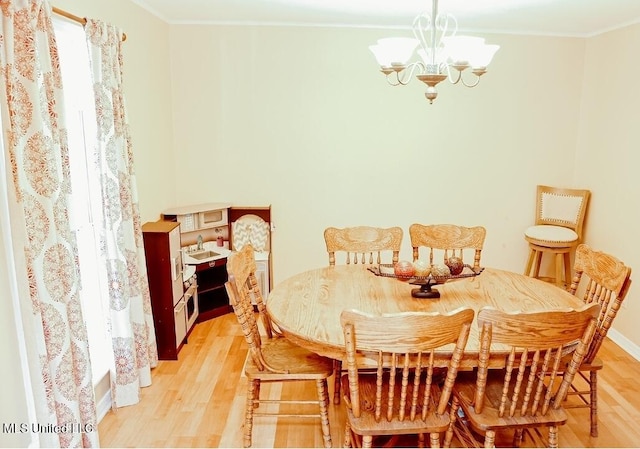 2208 Highland Dr, Gautier, MS 39553 - dining area with a chandelier, light wood finished floors, ornamental molding, and baseboards