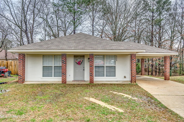 ranch-style home with concrete driveway, a front lawn, a carport, and brick siding