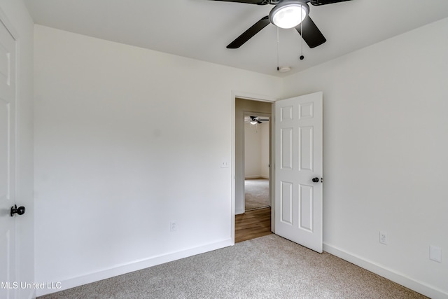 unfurnished bedroom with carpet floors, a ceiling fan, and baseboards