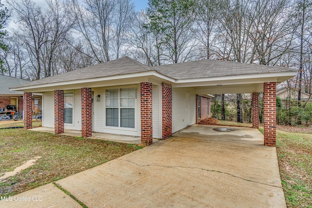 view of front of home with a carport, a front lawn, concrete driveway, and brick siding