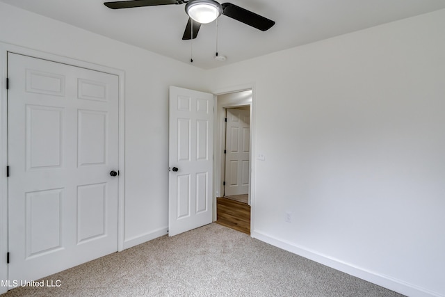 unfurnished bedroom featuring baseboards, ceiling fan, and light colored carpet