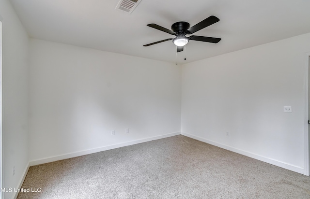 spare room featuring carpet, visible vents, ceiling fan, and baseboards