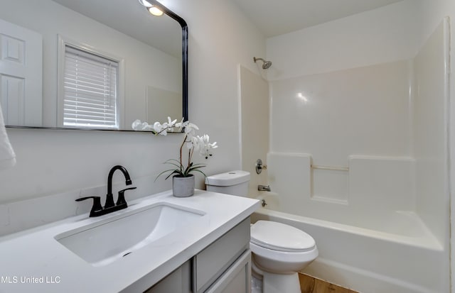 bathroom with tub / shower combination, vanity, and toilet