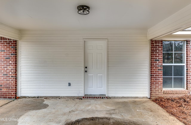 view of exterior entry with brick siding