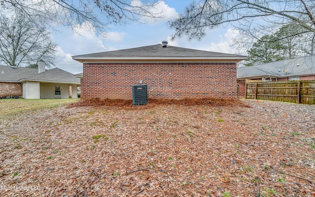 back of property featuring brick siding and fence