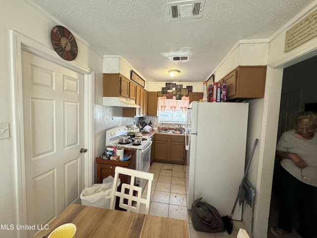 2730 E Angela Cir, Gulfport, MS 39503 - kitchen featuring white appliances, under cabinet range hood, a textured ceiling, a sink, and brown cabinets