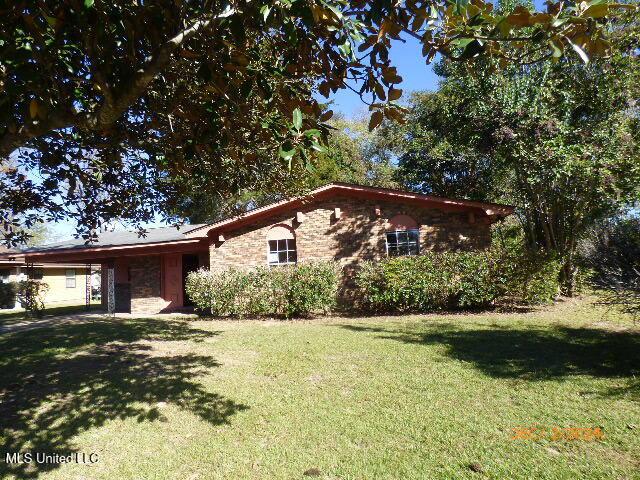 view of front of house with a front lawn and a carport