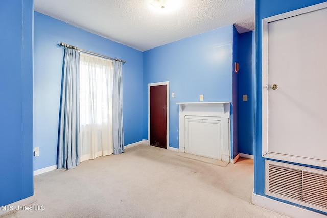 unfurnished room with carpet floors and a textured ceiling