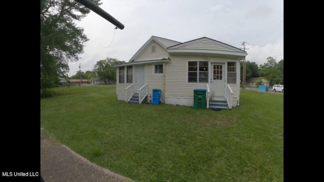 rear view of property featuring a lawn