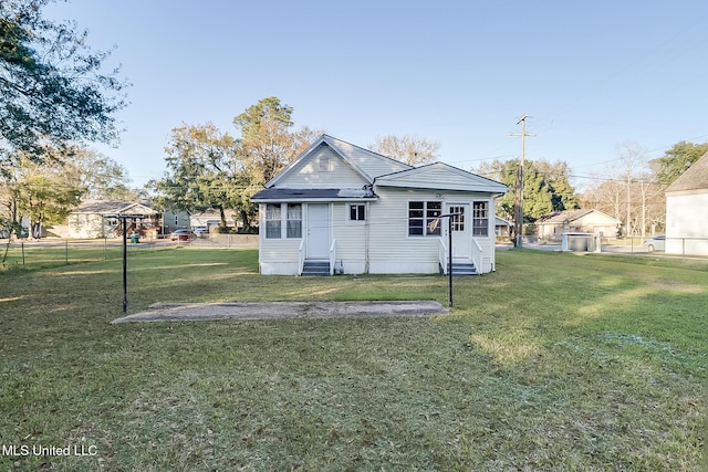 rear view of house featuring a yard