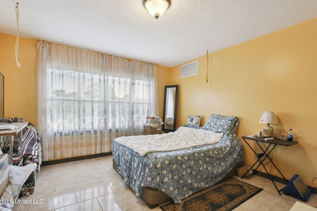 tiled bedroom with a textured ceiling