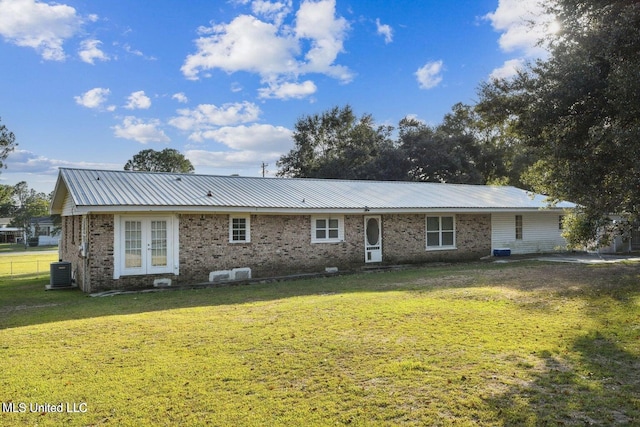 rear view of property with a lawn, central air condition unit, and french doors