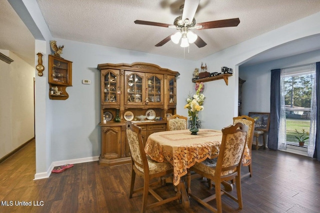 dining space featuring a textured ceiling, ceiling fan, and dark wood-type flooring