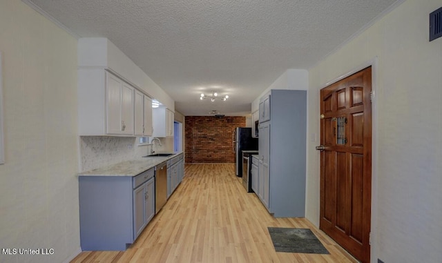 1431 Ranger Dr, Southaven, MS 38671 - kitchen featuring a sink, light wood-style flooring, a textured ceiling, stainless steel appliances, and light stone counters