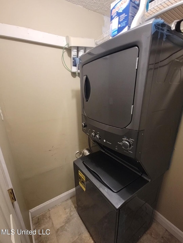 1704 Pat Dr, Gautier, MS 39553 - clothes washing area with laundry area, stacked washer and dryer, baseboards, and a textured ceiling
