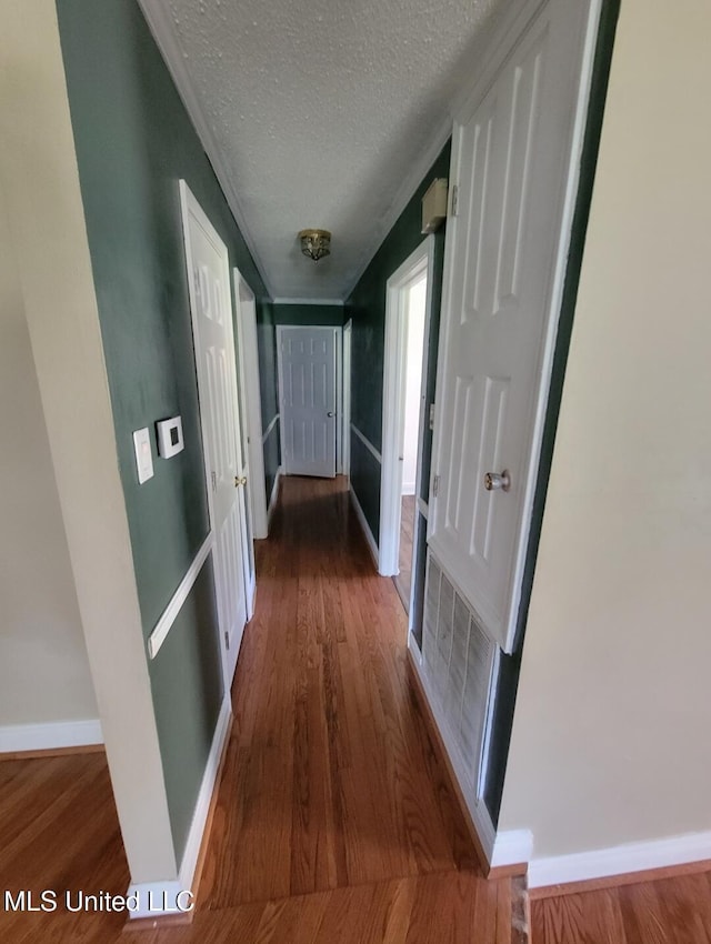1704 Pat Dr, Gautier, MS 39553 - hallway with baseboards, a textured ceiling, wood finished floors, and visible vents