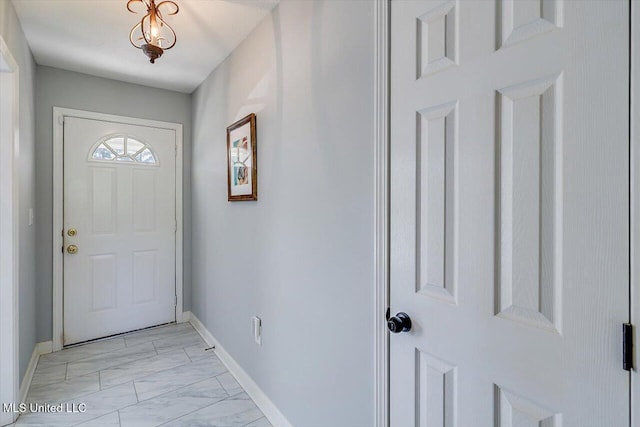 entryway with baseboards and marble finish floor