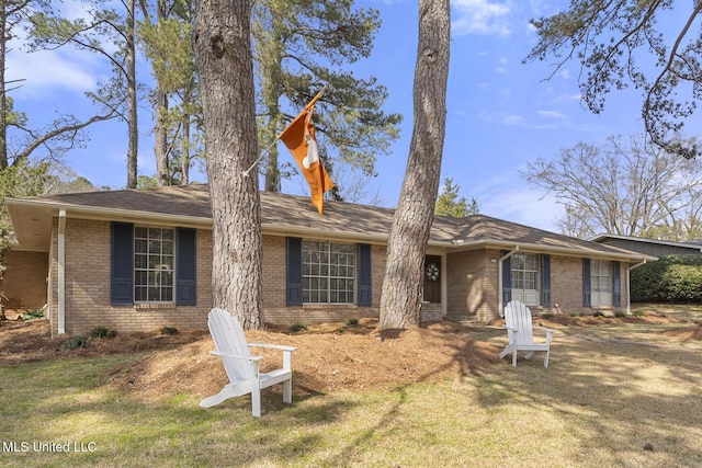 single story home with a front lawn and brick siding