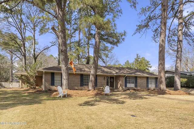 view of front of home featuring brick siding, a front yard, and fence