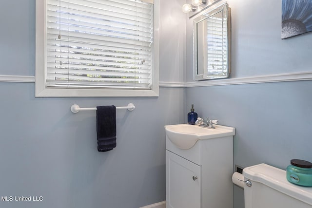 half bathroom with vanity and toilet