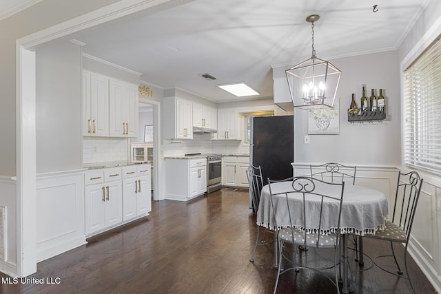 dining room featuring visible vents, crown molding, a chandelier, wainscoting, and dark wood-style floors