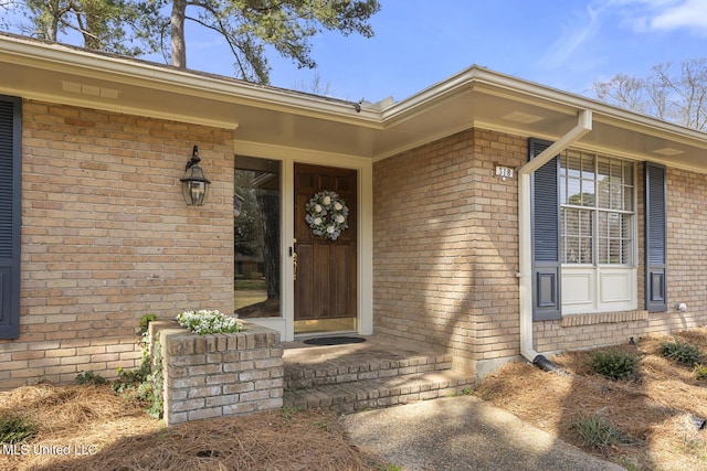 view of exterior entry featuring brick siding