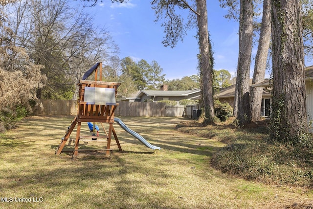 view of playground featuring a yard and fence