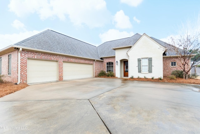 view of front of home featuring a shingled roof, concrete driveway, brick siding, and an attached garage